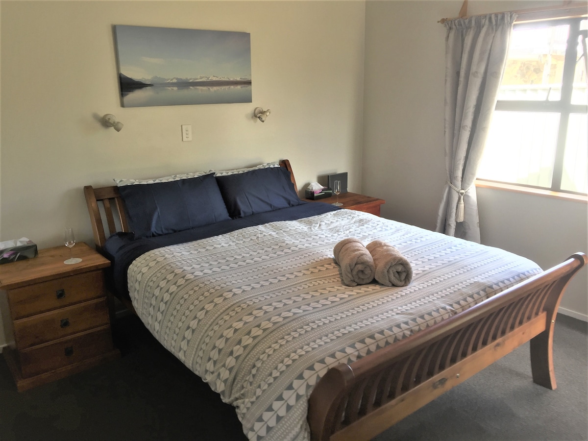 غرفة نوم كبيرة في الطابق الأرضي مع سرير مريح بمقاس كينج وحمام داخلي (دش ومرحاض)