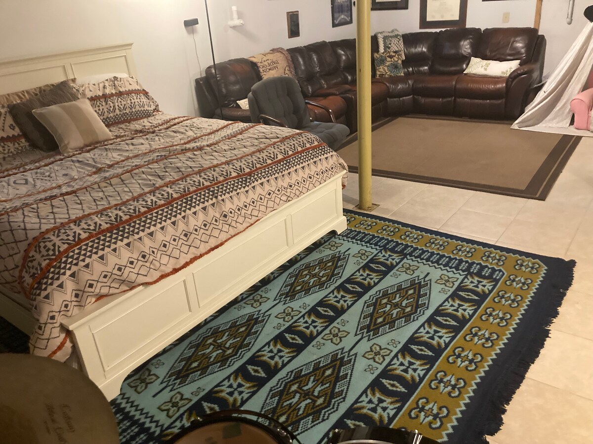 地下室的主要区域设有一张加大双人床、组合沙发和大型平板电视。 