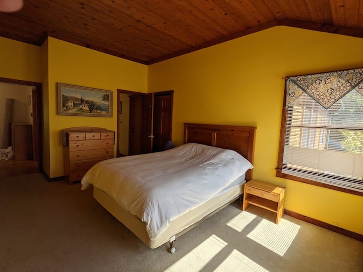 Dormitorio soleado con baño privado junto a la cocina.
