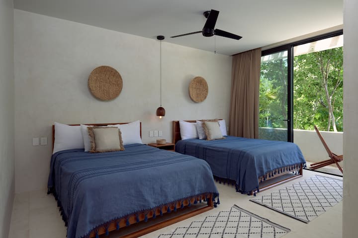 غرفة نوم للضيوف بسريرين بحجم كبير وحمام داخلي وخزانة ملابس وتراس خارجي.