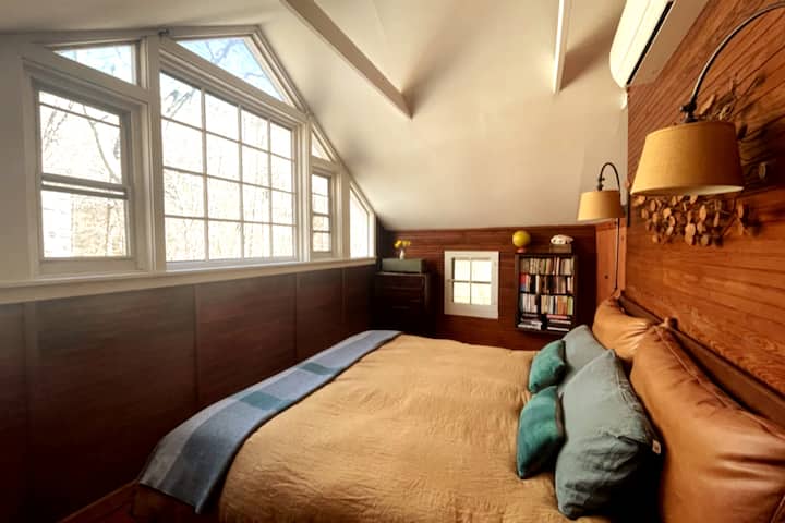 Mojawapo ya vyumba viwili vya kulala vya ghorofa ya juu vilivyo na kitanda chenye ukubwa mzuri na mandhari ya msituni. 