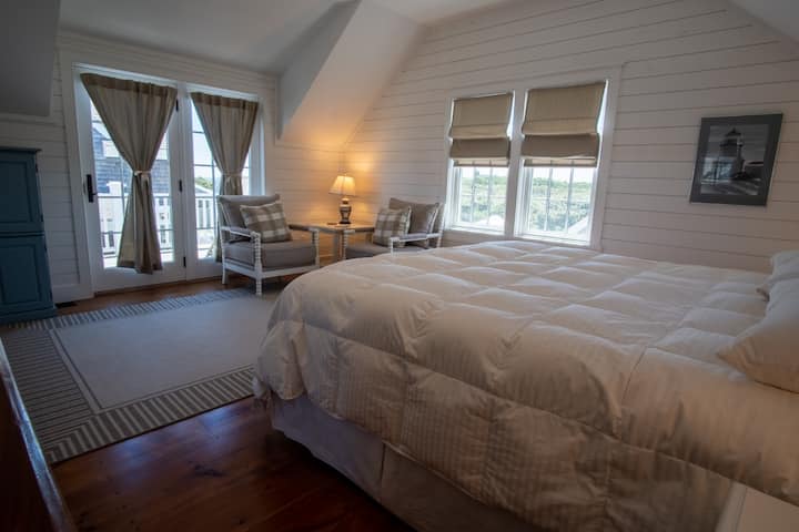 Over the garage is an additional bedroom suite. This bedroom with a king bed, sitting area, and private deck is accessed by a covered porch directly off the pool patio living area. This space is a terrific private guest suite for a couple.