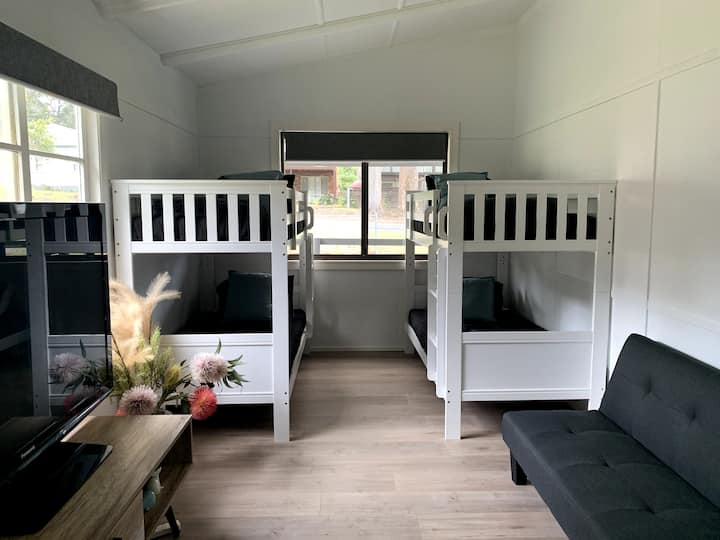 חדר שינה שני עם שני מיטות, ספה וטלוויזיה גדולה