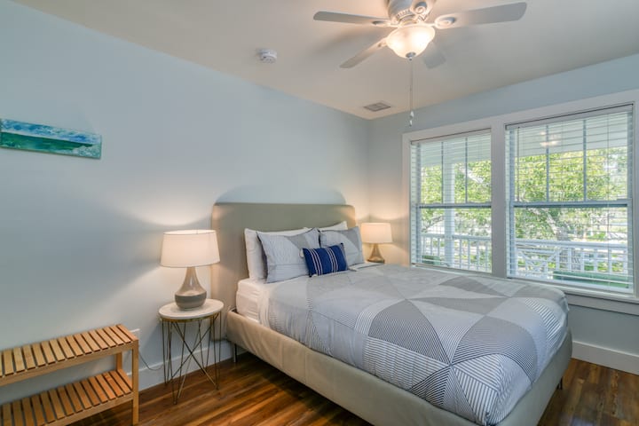 Queen room upstairs with wall hung TV, ceiling fan, closet and dresser. 