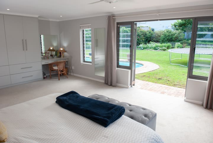 Quarto principal com cama king size. Portas com vista para o jardim. Entre no armário e grande banheiro privativo.