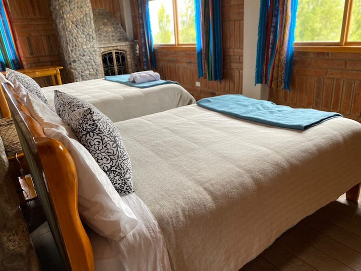 Hier hebben we de hoofdkamer met twee bedden, de ene is queensize en het andere is tweepersoons. De twee bedden zijn supercomfortabel gemaakt van rustiek hout. Het heeft verborgenheden en dekbedden om van hun nacht een zeer comfortabele ervaring te maken. 