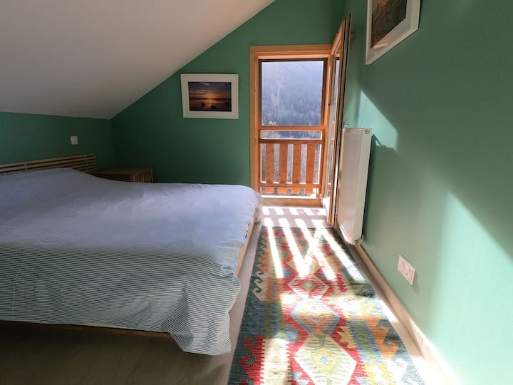 Övervåningen Dubbelrum med dubbelsäng och utsikt mot vattenfallet