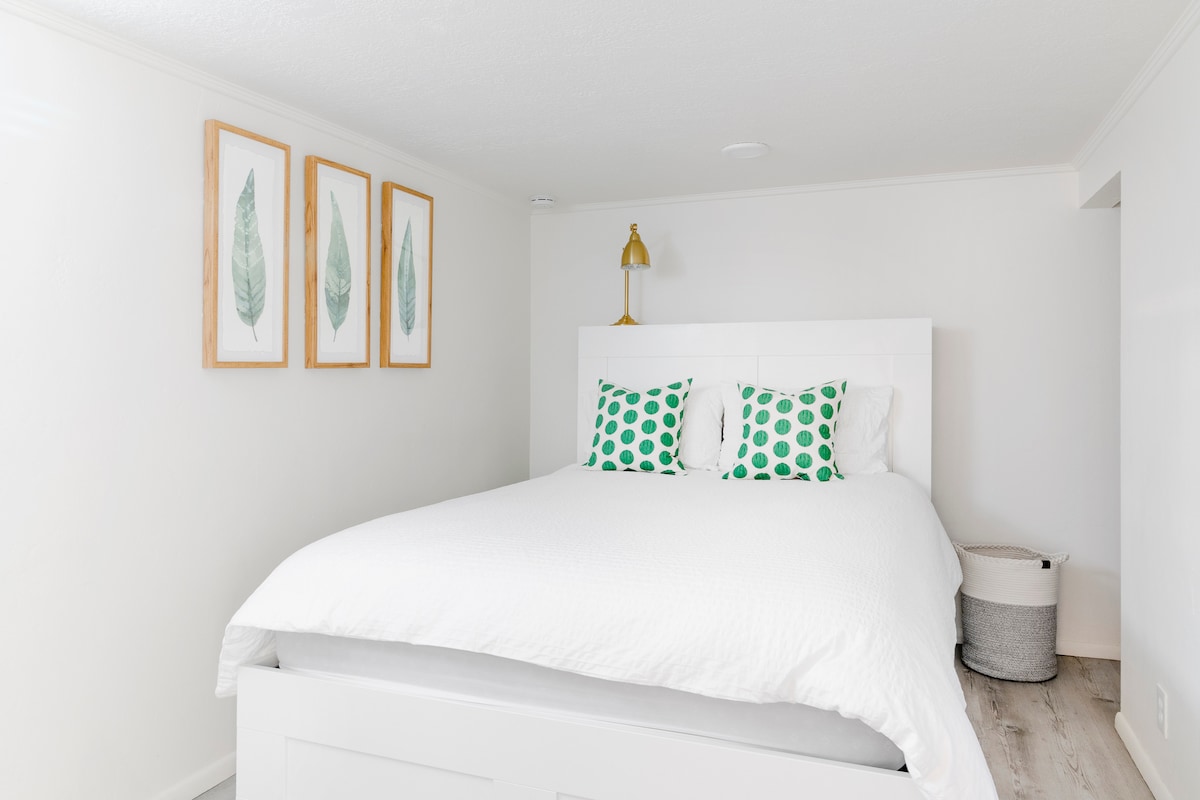 Lit queen size avec tiroirs de rangement sous le lit.