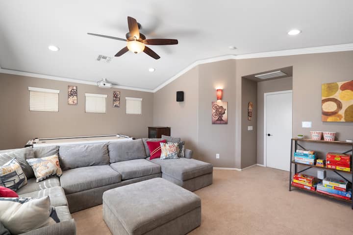 Chumba kikubwa cha sinema kilicho na meza ya mpira wa magongo, michezo na huduma za kutazama video mtandaoni. Kochi lina kitanda chenye ukubwa kamili.