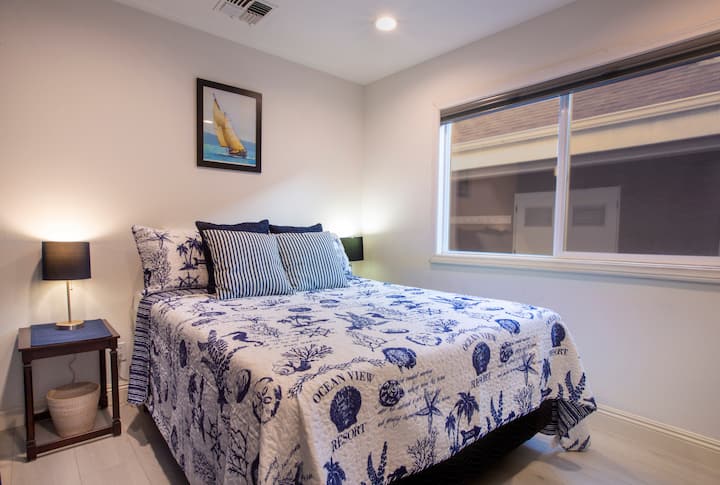 Bedroom One, features queen sized bed with bedding, two night stands, and a t.v. with DVD player.