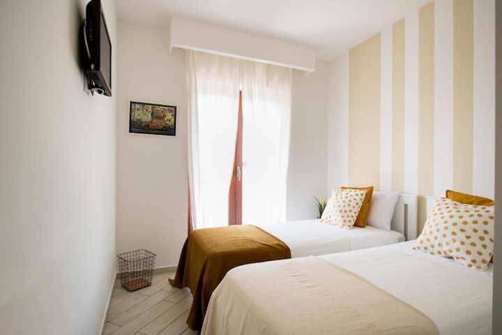 חדר שינה חמוד עם שתי מיטות יחיד וארון בגדים גדול לאחסון מלתחה.