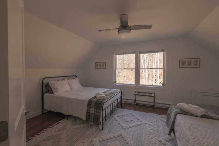 Our upstairs queen room with two queen beds and forest views

All bedrooms feature a Dohm white noise machine, ceiling fan and custom climate control. 