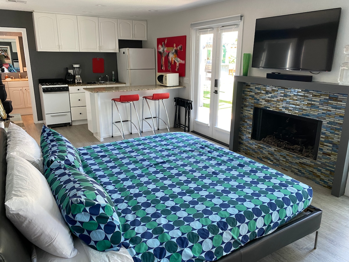 Habitación gris con cocina y baño a través de la puerta