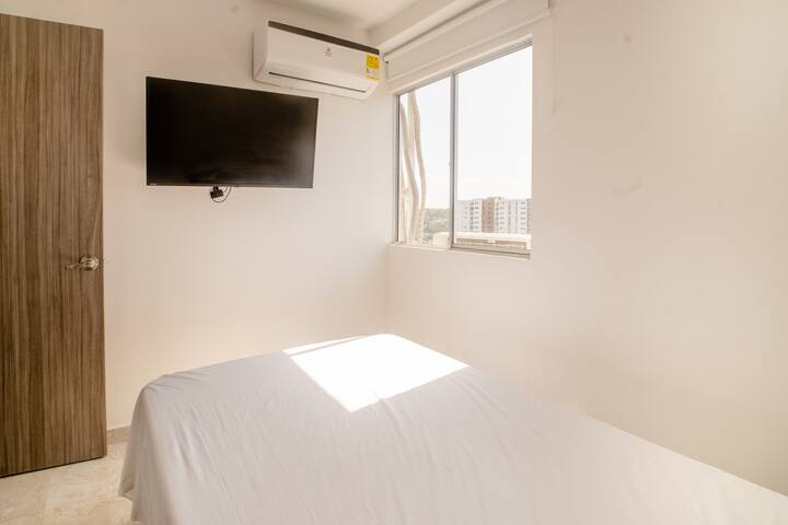 Room # 2 with a bed, tv, and air conditioner. 

Habitación # 2 con una cama, tv y aire acondicionado.

