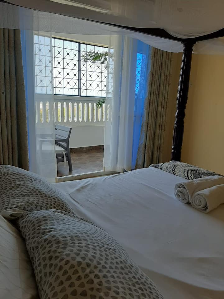 Habitación con baño privado con vista al mar y acceso al balcón
