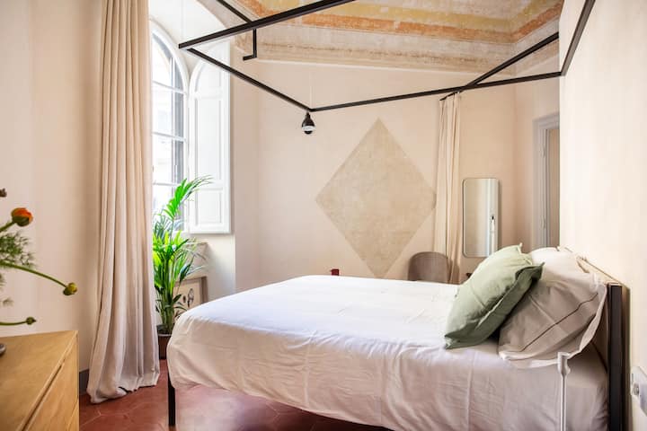 The bedroom, equipped with en-suite bathroom with circular marble shower,  has a central bed, decorated vaulted ceiling, furnishings and accessories both vintage and contemporary.