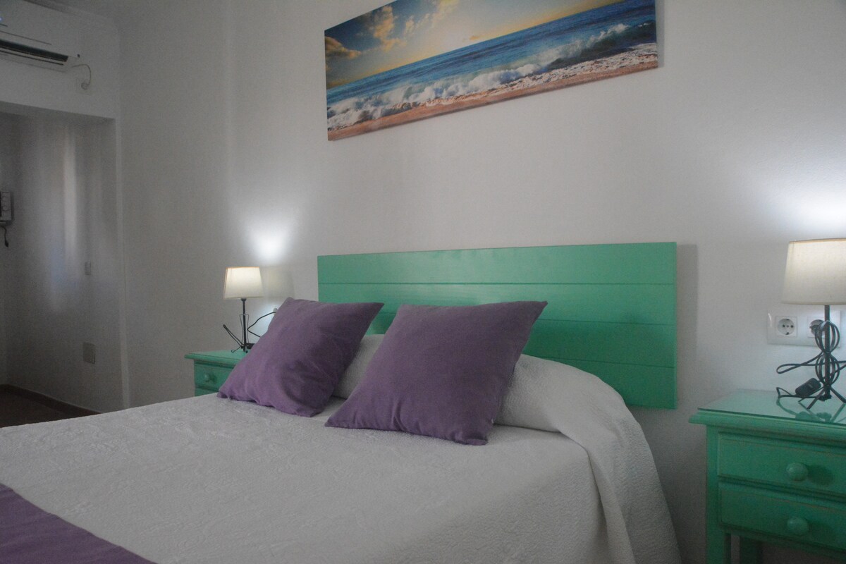 Spavaća soba s klima-uređajem i grijanjem, namještaj obojen zelenom bojom, s bračnim krevetom, TV