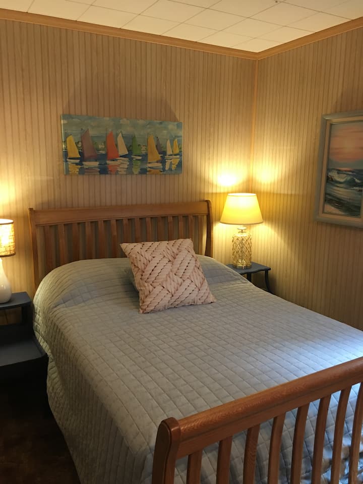Full bed with two bedside tables and lamps.