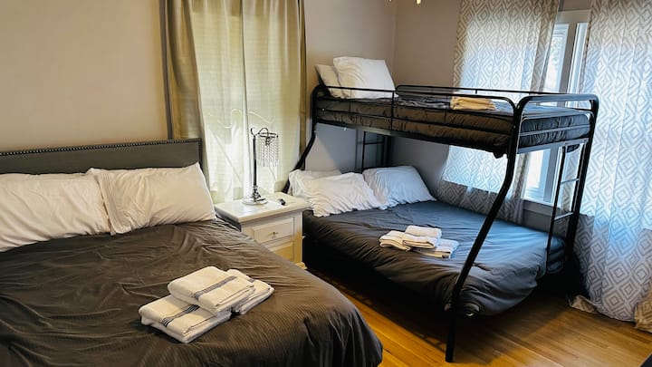 Esta casa vacacional de Mount Pleasant tiene una recámara en la planta alta con dos camas matrimoniales, una cama individual, pisos de madera y una Smart TV de 50 pulgadas.