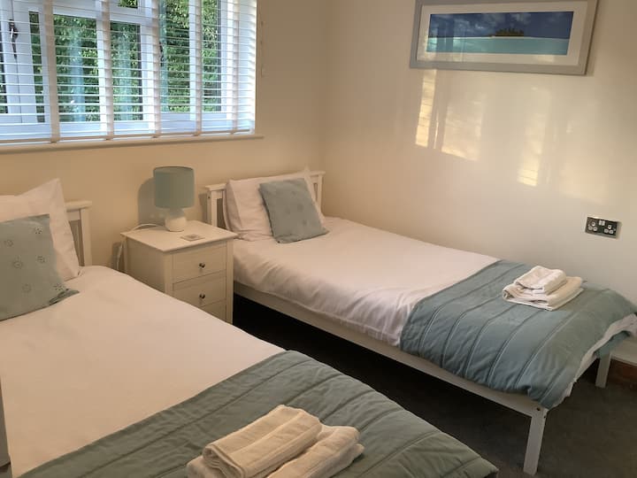 2ème chambre avec 2 lits simples, armoire de chevet, penderie simple et commode.