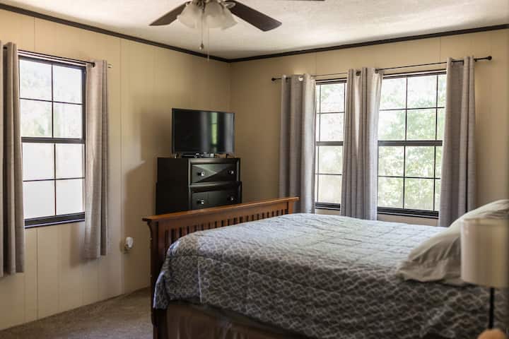 تحتوي غرفة النوم هذه على سرير بحجم كبير مع تلفزيون.