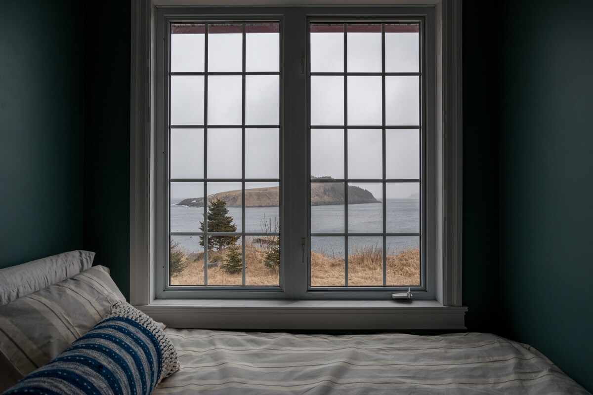 If you sleep with the windows open in the second queen bedroom at the three-bedroom Newfoundland Ocean Lodge, you can fall asleep to the sounds of whales and waves. This bedroom overlooks the islands, humpback whale feeding grounds, and the ocean