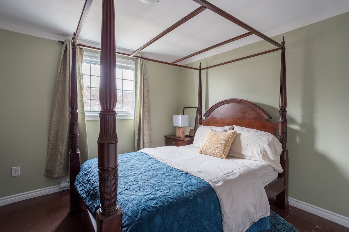 The Classic Queen Bedroom at the Newfoundland Ocean Lodge features a romantic four-poster bed and a great place to relax after whale watching, hiking the East Coast Trail, or reading the new book you picked out at the bookstore up the lane