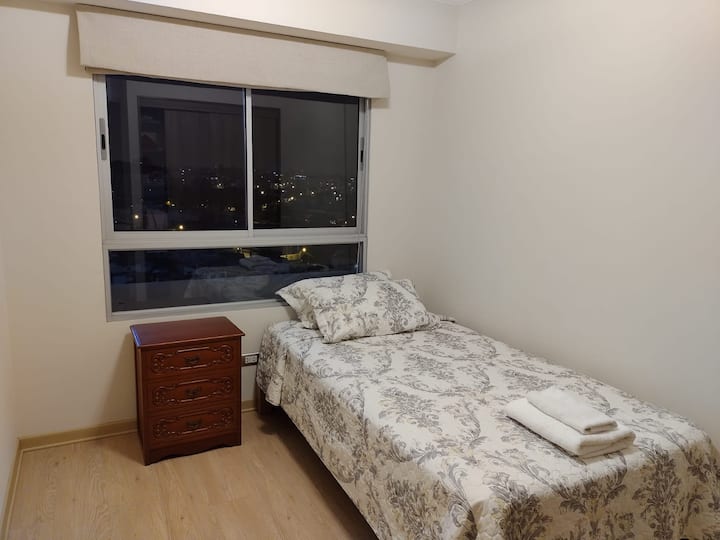 Habitación1 simple con velador, cortina store, ventana con vidrio templado, closet incorporado , cama de plaza y media y tacho cesta para ropa usada. Sábanas de algodón, ropa de cama de alta calidad y cubrecama.