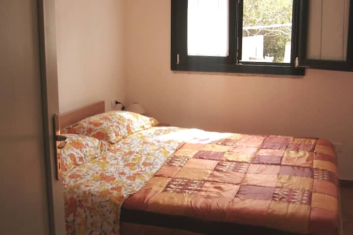 Chumba cha kulala chenye vitanda viwili na meza pembeni ya kitanda.