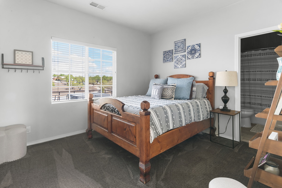 בחדר הרחצה הצמוד יש גם כניסה למסדרון. נוף לדק, צלע גבעה ומטע.