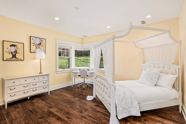 Chambre au niveau inférieur avec lit double, bureau, commode et placard.