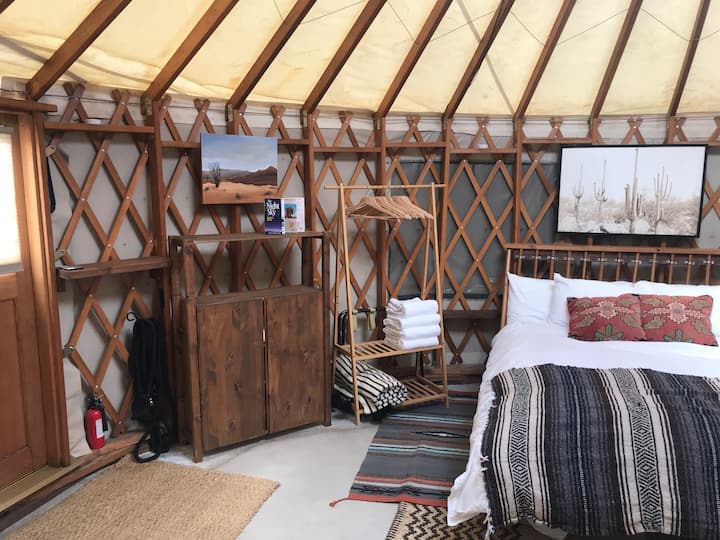 Clothing rack next to bed area.