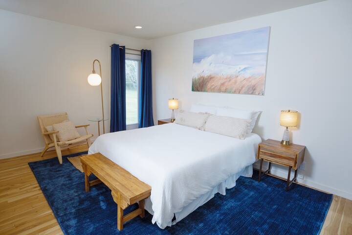 Dormitorio queen en la planta baja con balcón privado, baño privado y acceso al patio trasero.