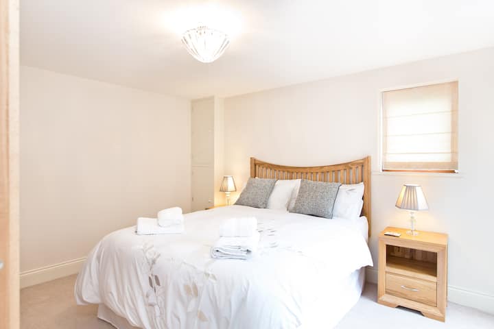 Dormitorio 1 en la planta baja, dormitorio doble espacioso y luminoso con una lujosa cama tamaño king y TV inteligente.