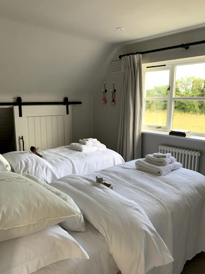 Chumba hiki kizuri sana kwenye ghorofa ya kwanza kina vitanda viwili vya mtu mmoja ndani yake. Chumba kizuri kwa watoto. Maoni juu ya meadow, hifadhi nyingi, bedlinen gorgeous.