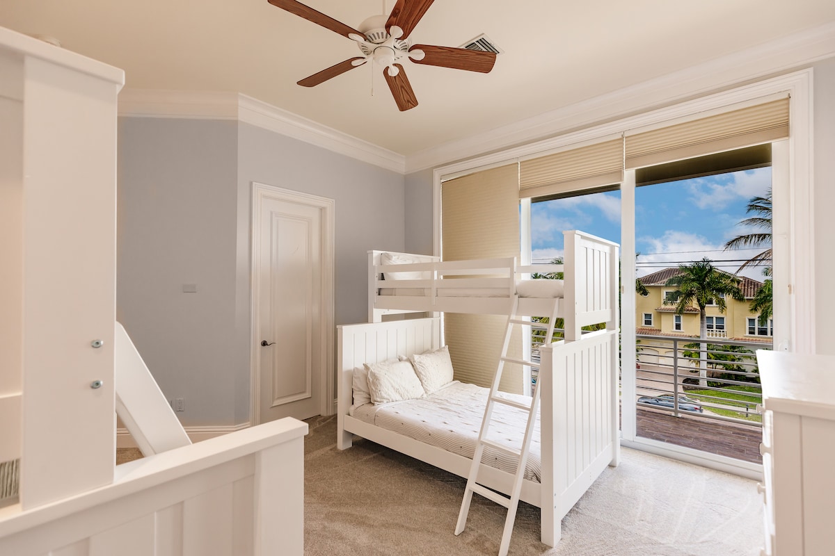 Soba s krevetima na kat u kojoj ima puno svjetla i koja ima dvostruke krevete i pješčani ugođaj