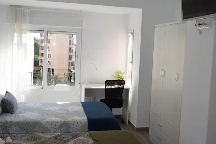 Camera da letto 2, con 2 letti di 105 cm, TV da 32", ventilatore a soffitto e vista sul Palazzo del Congresso