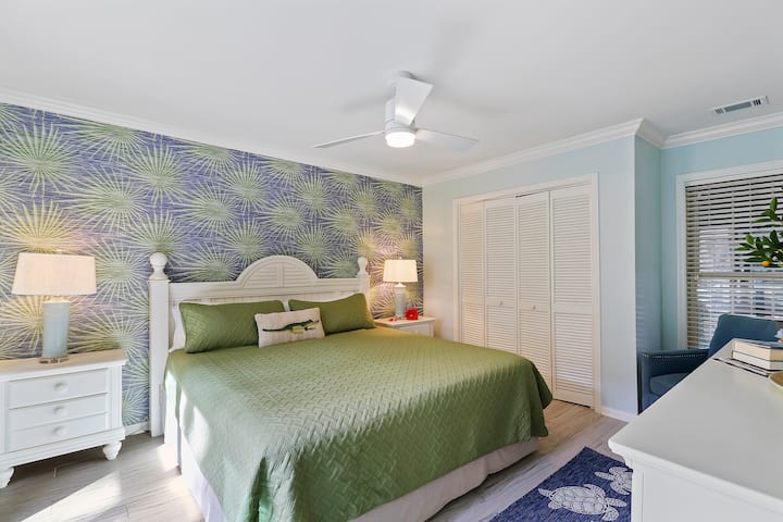 El dormitorio principal con una impresionante pared tiene una cama tamaño king con sábanas nuevas en 2023.