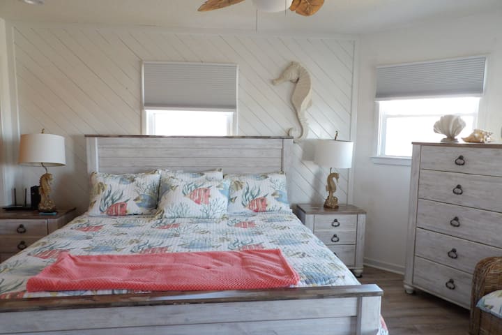 el dormitorio principal del primer piso, el dormitorio king en la suite, la bañera de hidromasaje se abre a la terraza frente al océano con un montón de asientos para el café de la mañana y los amaneceres.