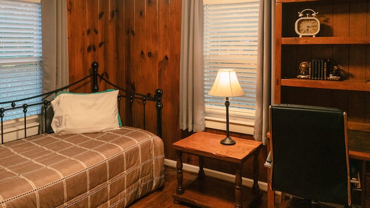 غرفة نوم بسرير نهاري وتدحرج تحت السرير يتدحرج إلى الغرفة مع مكتب عمل. تبلغ مساحة غرفة النوم هذه 9 × 12