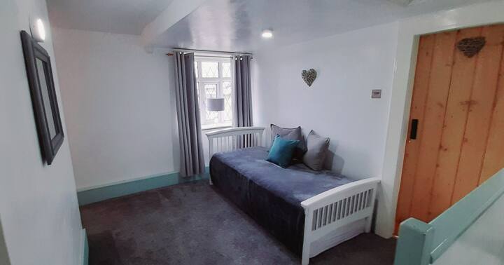 Spacious landing with daybed (2 × single beds) and blackout curtains. Fantastic area for additional guests or to relax. Views from the window over the surrounding countryside.