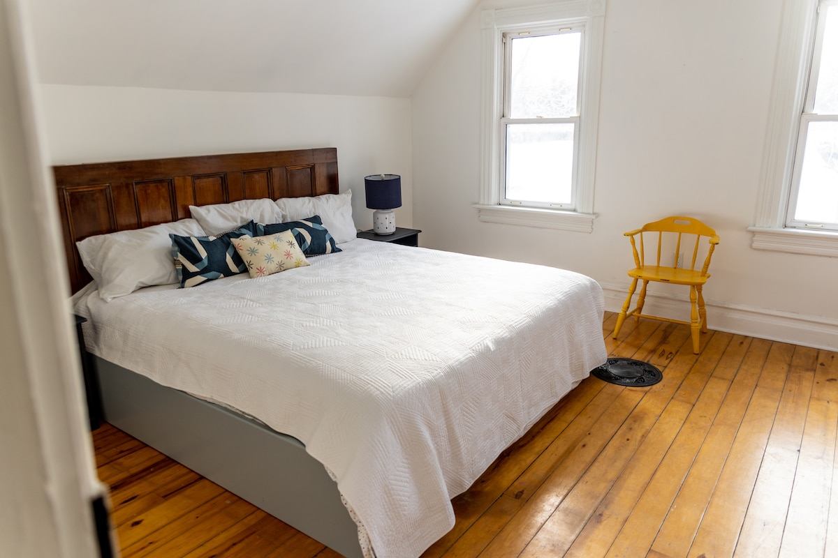 Dormitorio sur con cama tamaño king y ventilador de techo.