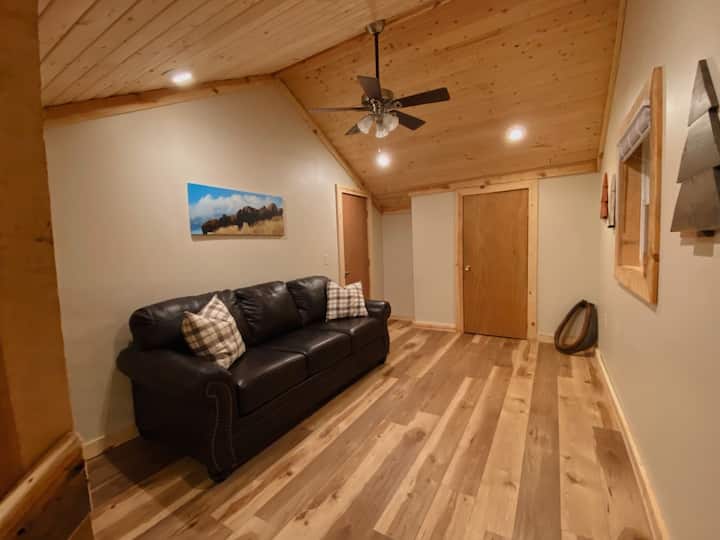 ห้องลอฟท์พร้อมเตียงโซฟาขนาดควีนไซส์  ประตูห้องนอนชั้นบน (ซ้าย) และห้องสุขา (ตรงไปข้างหน้า)