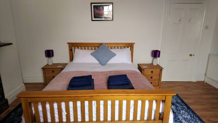 الغرفة الثالثة بحجم كينغ في الطابق الأوسط في الجزء الخلفي من المنزل مع لمحة عن المضيق فوق أسطح المنازل. 