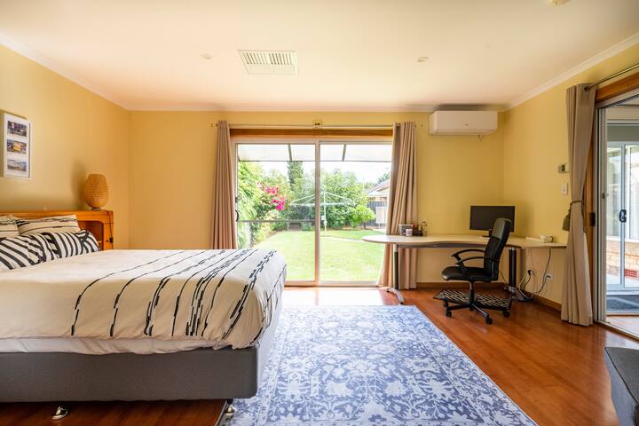 Bedroom has queen size bed with oak headboard, wardrobe, desk & office chair. Has access to ensuite, consisting of separate shower, toilet and dressing area, with large mirror. Has glass sliding doors with view to, and open onto  garden/ lawn.