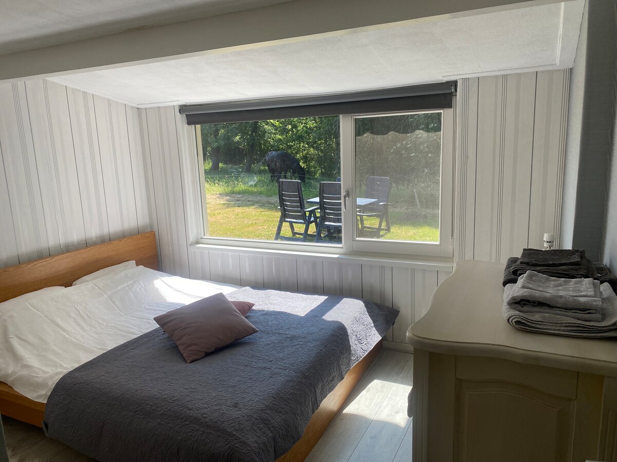 חדר שינה עם מיטה זוגית ומיטת תינוק/שידה המשקיפה על האחו.