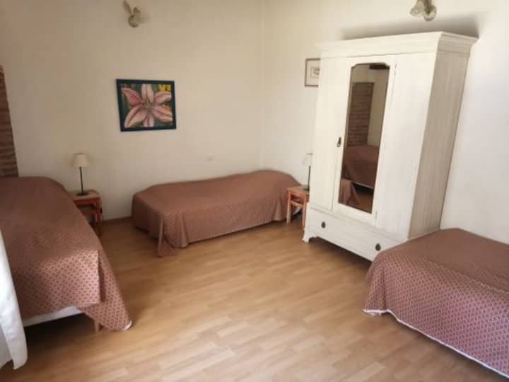 חדר אדום עם שלוש מיטות יחיד. 