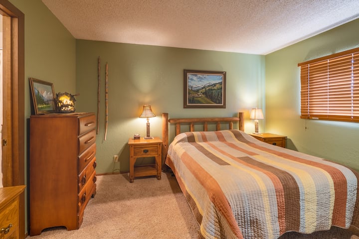 Quarto principal com cama queen size e banheiro anexo