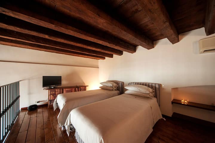 The loft double room is furnished with two extra-long single beds, which can be flanked upon request. It is equipped with a TV, hi-fi and air conditioning, offering a comfortable and well-equipped stay.