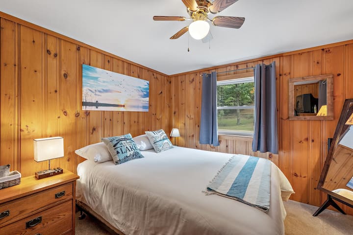 Main floor bedroom with double bed and nostalgic VHS player TV with an assortment of tapes.